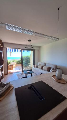 un salon avec un canapé et une table dans l'établissement Appartement design 1ère ligne avec vue panoramique sur la mer, à Cannes