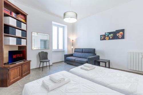 Un dormitorio con una cama, un televisor y una silla. en Vatican Essence, en Roma