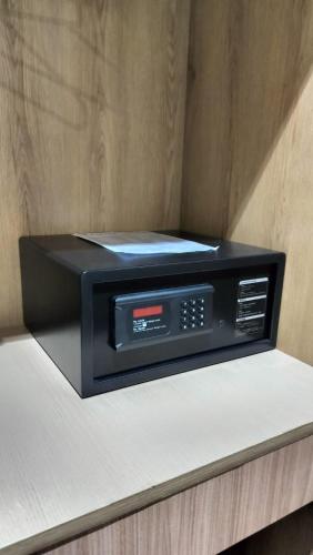 a black microwave sitting on top of a counter at The Rajgir Residency in Rājgīr