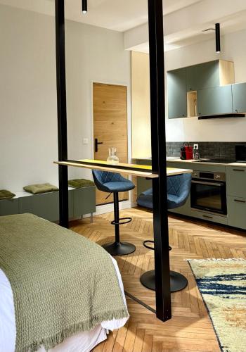 une chambre avec un lit et une table et une cuisine dans l'établissement id-home le St Nicolas, à Nantes