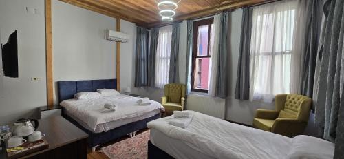 a hotel room with two beds and a chair at Grand Bedir in Istanbul