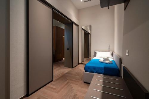 a bedroom with a blue bed and a mirror at 4 Season Cognetti in Bari