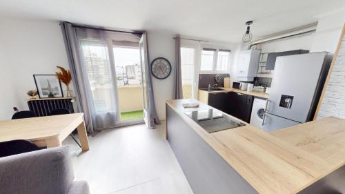 une petite cuisine avec un comptoir et un réfrigérateur dans l'établissement F3 Rue Frederick Lemaitre, au Havre