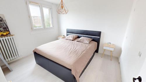 une chambre avec un lit avec une tête de lit noire et une fenêtre dans l'établissement F3 Rue Frederick Lemaitre, au Havre