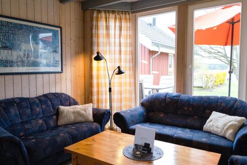 a living room with two blue couches and a table at SATAMA Sauna Resort & SPA in Wendisch Rietz