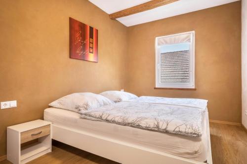 a bed in a room with a window and a bed sidx sidx sidx at Ferienwohnung Lang in Kressbronn am Bodensee