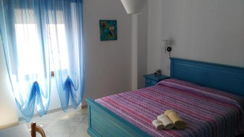 1 dormitorio con 1 cama azul y 2 toallas en B&b Sa Zodia Guest House en Bitti