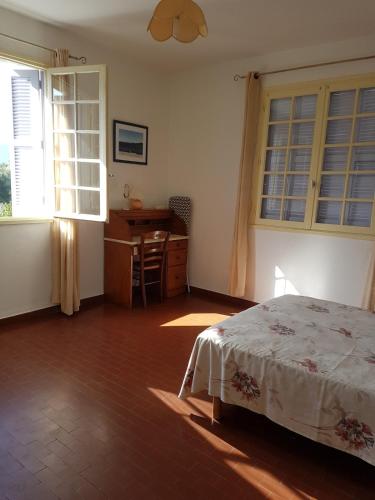 une chambre avec un lit, un bureau et des fenêtres dans l'établissement Appartement 1 à Regino Speloncato pour 3 personnes, à Speloncato