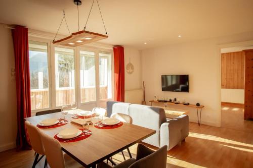 a living room with a table and a couch at L'Edelweiss - Au pied des montagnes in La Lechere