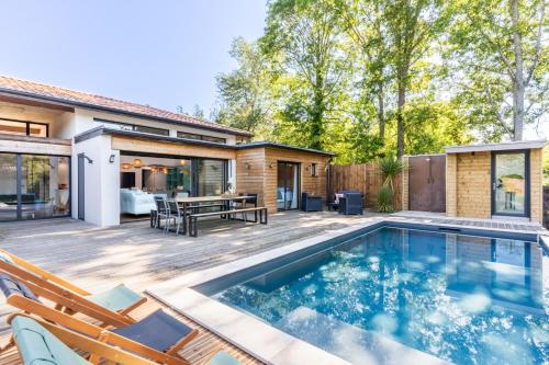 une cour arrière avec une piscine et une maison dans l'établissement Villa ELVIRA proche de l'océan, Angresse proche Hossegor, à Angresse