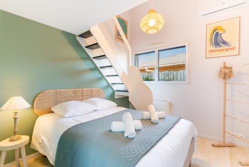 une chambre avec un lit et un escalier en colimaçon dans l'établissement Villa ELVIRA proche de l'océan, Angresse proche Hossegor, à Angresse