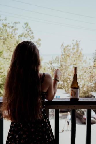 a woman standing at a table with a bottle of wine at Fészek -Étel és Hotel- in Zánka