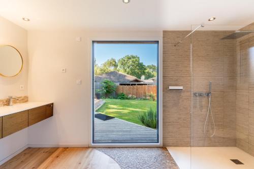 une salle de bain avec une douche avec une porte vitrée dans l'établissement Villa ELVIRA proche de l'océan, Angresse proche Hossegor, à Angresse