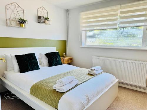 ein Schlafzimmer mit einem weißen Bett mit Handtüchern darauf in der Unterkunft The Jade House - Cambridge Rental with Garden and BBQ, Near City Centre in Cambridge