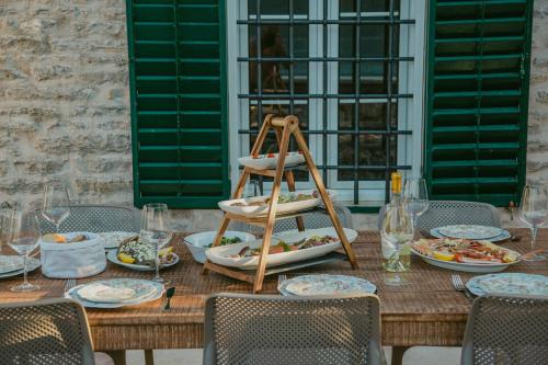 a wooden table with plates of food on it at Villa Toma in Donji Morinj