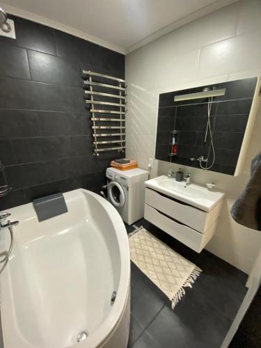 a bathroom with a tub and a toilet and a sink at Avangard in Chernivtsi