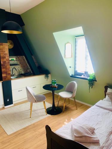 a bedroom with a bed and a table and chairs at Apartamenty w centrum Wawel & Smok AC Progres in Toruń