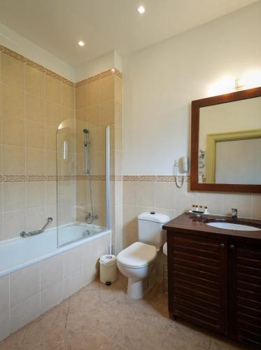 a bathroom with a toilet and a tub and a sink at Delta Nature Resort in Tulcea