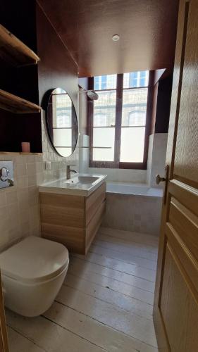 une salle de bain avec toilettes, lavabo et miroir dans l'établissement St Michel 3 bedrooms appartment, à Bordeaux
