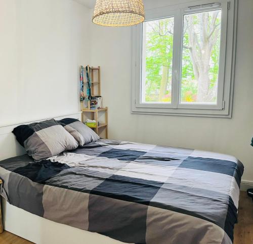 un lit dans une chambre avec une fenêtre dans l'établissement Au Point Carré - Appartement tout confort au calme, à Bordeaux
