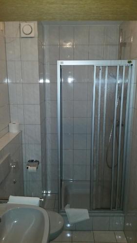 a bathroom with a shower with a sink and a toilet at Café und Hotel Zum Grünen Baum in Sonneberg