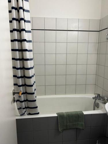 une salle de bain avec une baignoire et un lavabo dans l'établissement Appartement La Rochelle accès plage avec vue, à La Rochelle