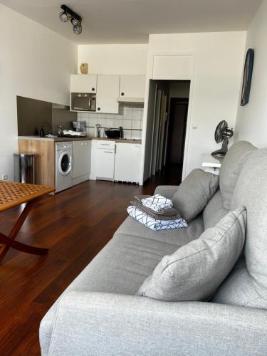 un salon avec un canapé et une cuisine dans l'établissement Appartement La Rochelle accès plage avec vue, à La Rochelle