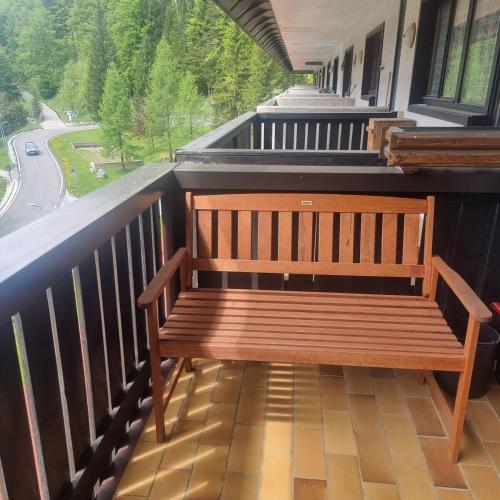 a wooden bench sitting on the balcony of a building at Casa JOY in Sella Nevea