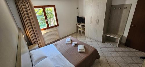 a bedroom with a bed in a room with a window at Regina Hotel e Ristorante in Punta Marina