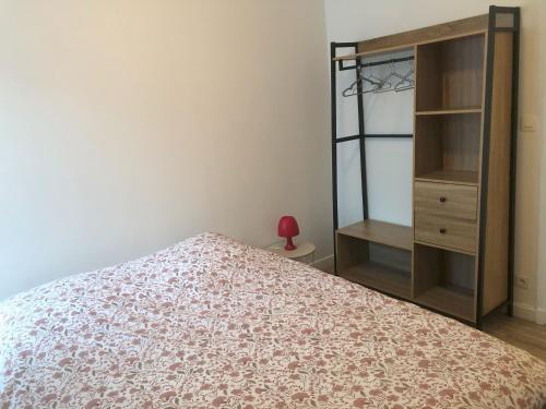 a bedroom with a bed and a wooden cabinet at Villa Jean Pierre in Pougues-les-Eaux