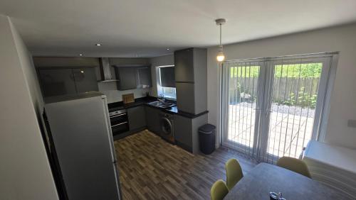 una pequeña cocina con una puerta que da a un patio en 4 Bedroom Home Tameside Greater Manchester Sleeps 8, en Mánchester