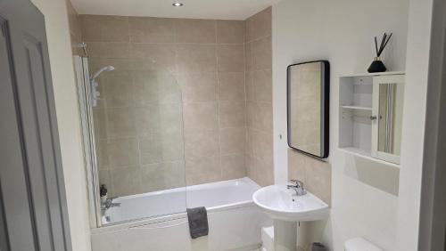 a bathroom with a sink and a bath tub and a toilet at 4 Bedroom Home Tameside Greater Manchester Sleeps 8 in Manchester