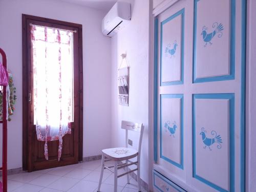 a room with a door and a chair and a table at Residenze Lu Rinaggiu in Agrustos