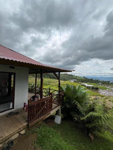 a porch of a house with a view of a field at Ikua Tanjuang in Situjuhbatul