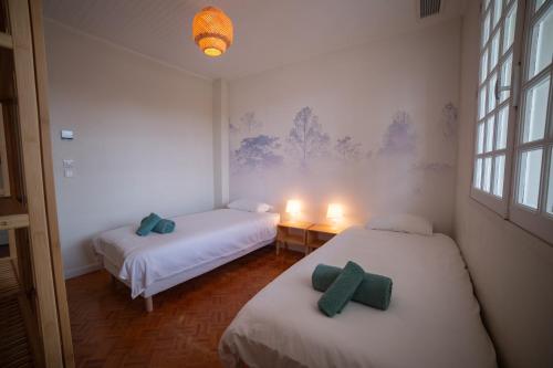 deux lits dans une pièce avec deux bougies dessus dans l'établissement Maison Dharma à 5km de la plage avec Sauna, à Mimizan