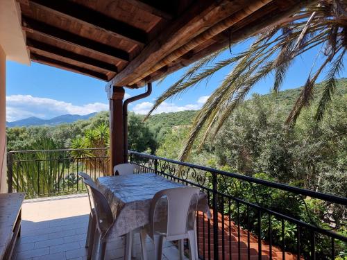 a table and chairs on a balcony with a view at Residenze Lu Rinaggiu in Agrustos