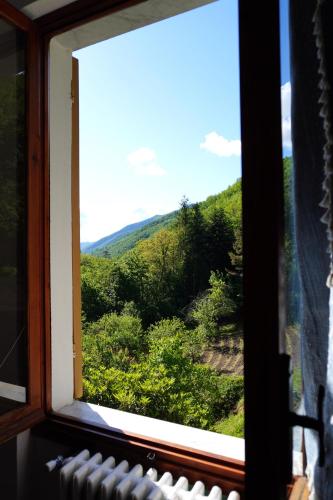 a window with a view of a mountain view at Casa Castagno e Ruscello - Nature Retreat in Liguria in Pieve di Teco
