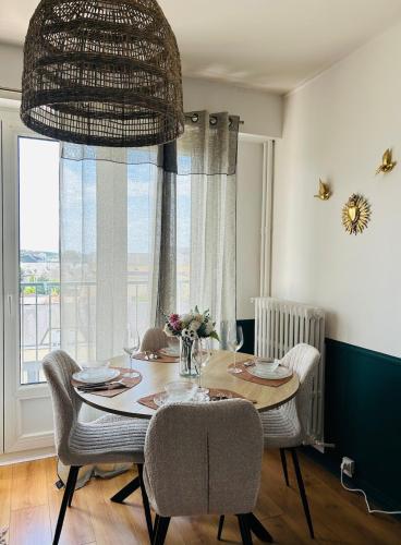 une salle à manger avec une table et des chaises et une fenêtre dans l'établissement Nid doux, au Mans