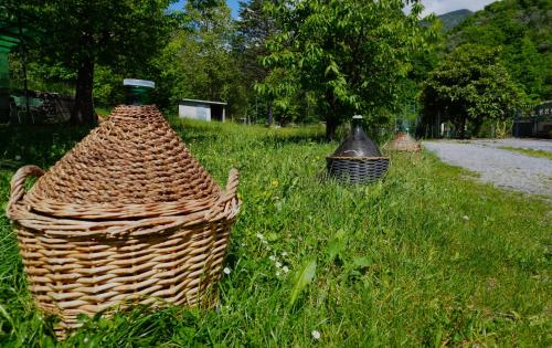 two baskets sitting in the grass next to a road at Casa Castagno e Ruscello - Nature Retreat in Liguria in Pieve di Teco