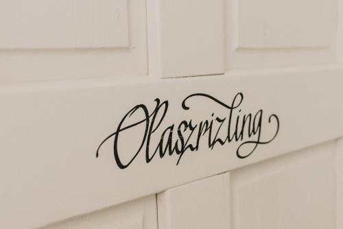 a calligraphy sign on a white kitchen cabinet at Fészek -Étel és Hotel- in Zánka