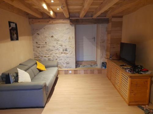 un salon avec un canapé et une télévision à écran plat dans l'établissement Maison familiale - 6 voyageurs, à Ceyzérieu