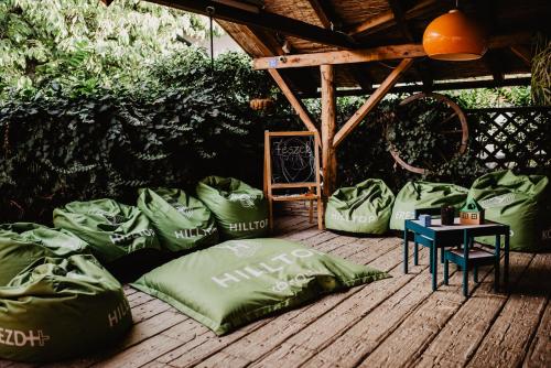 a group of green pillows on a wooden deck at Fészek -Étel és Hotel- in Zánka