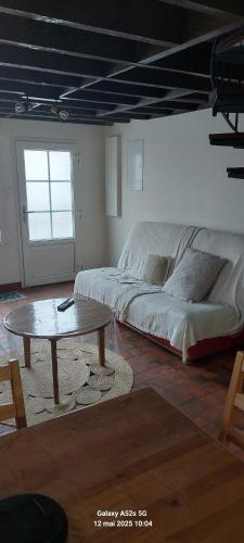 - un salon avec un lit et une table basse dans l'établissement Maison des Gabelous, à Guipry-Messac