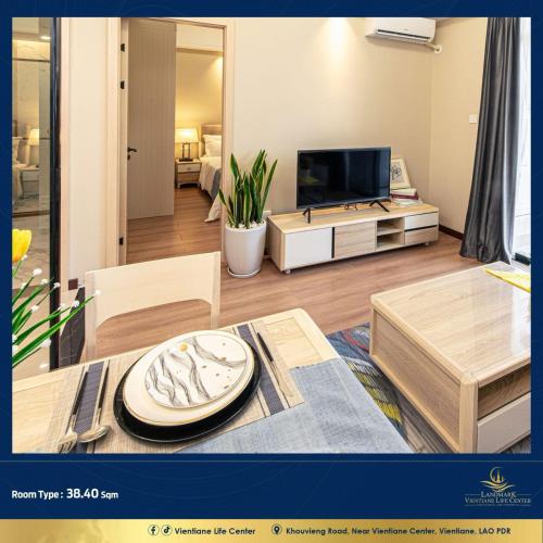 Una sala de estar con un televisor y una mesa. en Vientiane Life Center Condo, en Vientiane