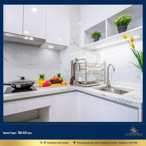 una cocina blanca con fregadero y frutas y verduras en Vientiane Life Center Condo, en Vientiane