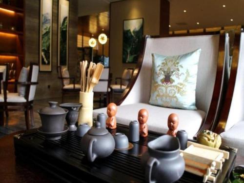 a room with a bed with a table with pottery on it at Suzhou Qingshan Conference Center in Suzhou