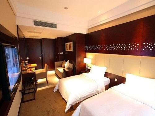 a hotel room with two beds and a flat screen tv at Suzhou Qingshan Conference Center in Suzhou