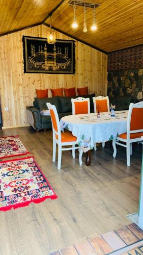 a room with a table and chairs and a couch at Haven A frame Shahdag in Qusar