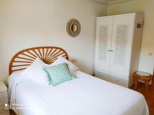 a bedroom with a white bed with a wooden headboard at Mirador de Palacios- céntrico con vistas y parking cerca in Albarracín