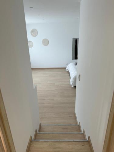a staircase in a room with white walls and wood floors at Vertu'Ose in Morbier